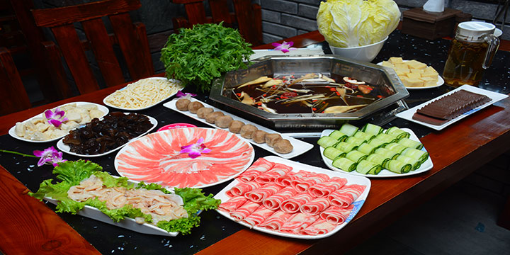 Chinese hot pot with divided broth, sliced ingredients and vegetables Chinese hot pot with divided broth, sliced ingredients and vegetables