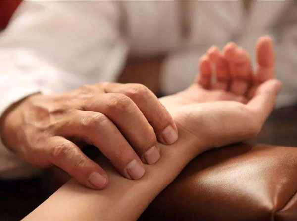 Practitioner taking a radial pulse during a TCM examination Practitioner taking a radial pulse during a TCM examination