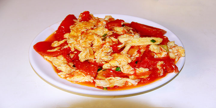 Chinese tomato and scrambled egg dish served on a white plate Chinese tomato and scrambled egg dish served on a white plate