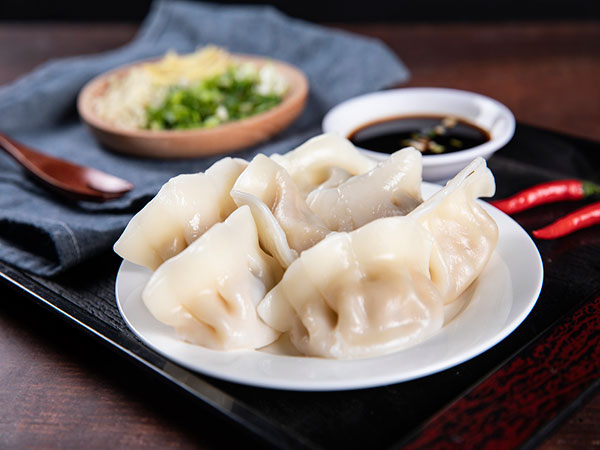 Boiled jiaozi dumplings served with dipping sauce