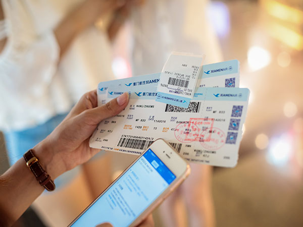 Traveler comparing flight tickets on a smartphone before a China trip Traveler comparing flight tickets on a smartphone before a China trip