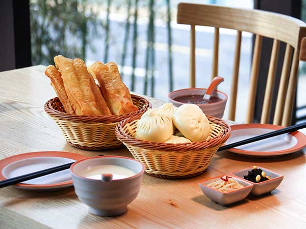 Chinese breakfast with youtiao, steamed buns, soy milk and side dishes