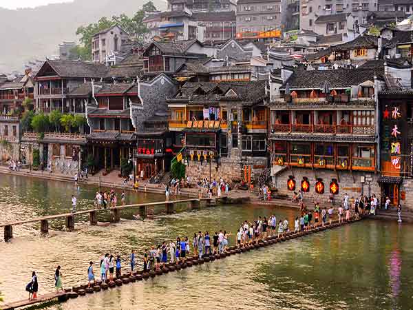 Traditional riverside houses reflected in the water at Fenghuang Ancient Town