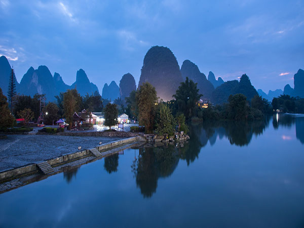 Karst mountains reflected in water near Guilin at blue hour