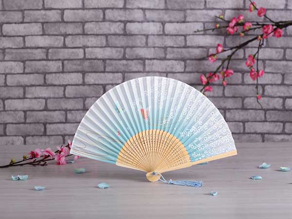 Painted folding fan displayed with plum blossoms