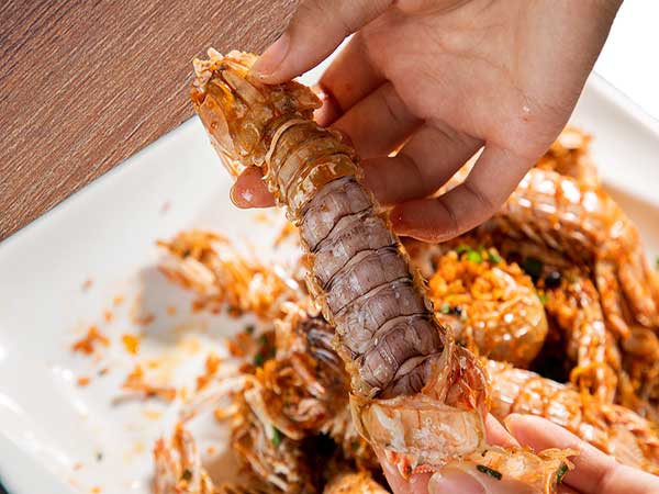 Fresh mantis shrimp being prepared at a seafood counter
