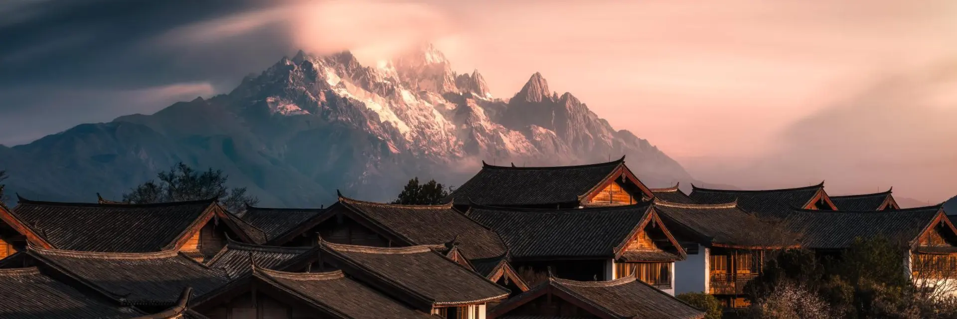 Jade Dragon Snow Mountain above traditional rooftops in Yunnan