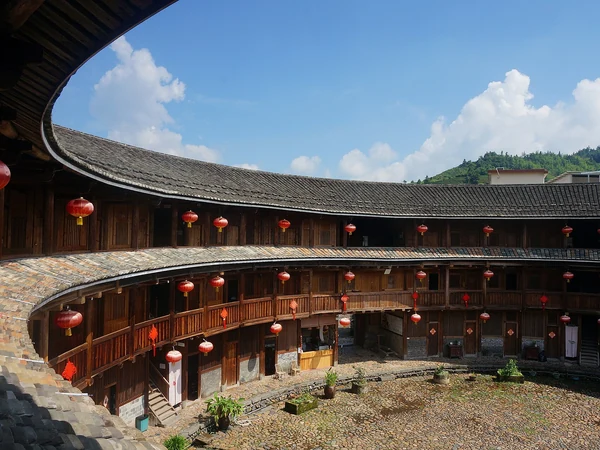 Round Fujian tulou set among forested hills