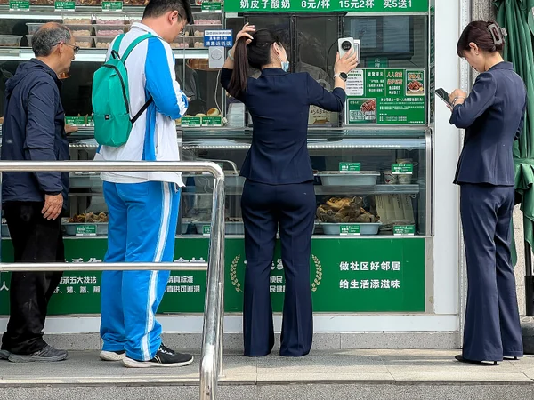 A customer using a mobile QR code to pay at a shop in Beijing