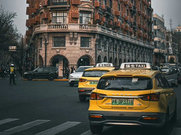 Yellow taxi traveling along a city street in Shanghai
