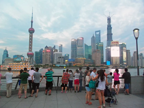 Visitors photographing the Lujiazui skyline from the Bund promenade