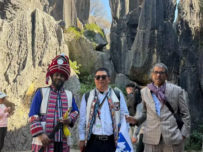 Traveler with an ethnic guide in the Stone Forest of Yunnan
