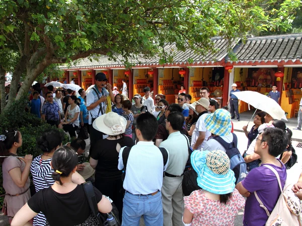 A tour guide addressing visitors at a heritage site in China