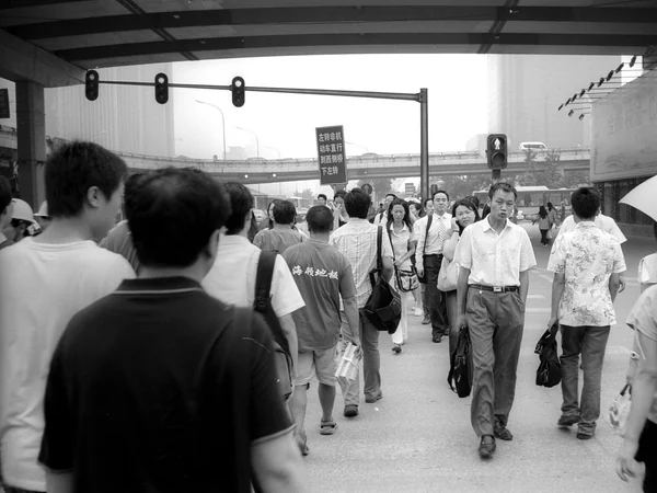 Pedestrians crossing a busy street in Beijing