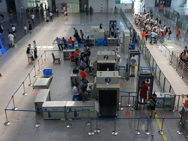Passengers and baggage passing through security screening at a Chinese railway station Passengers and baggage passing through security screening at a Chinese railway station
