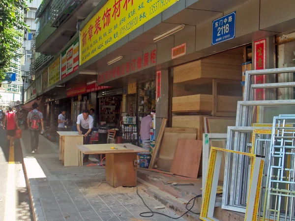 Woodworker applying finish to a small wooden craft in China