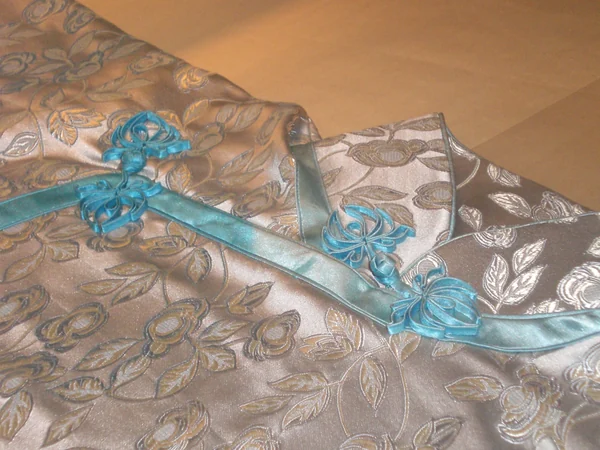 Qipao fabrics and frog fastenings in a museum display