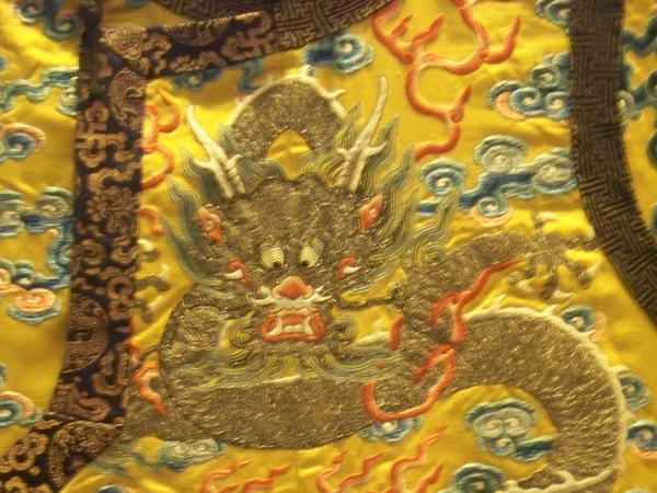 Embroidered Qing imperial robe displayed in a museum