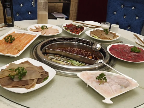 Several dishes shared in the center of a Chinese dining table