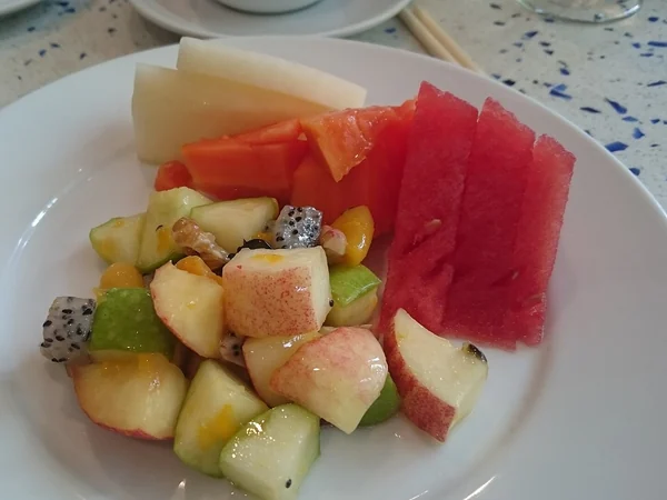 Fresh fruit served at the end of a group meal in China