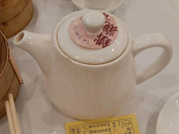 Hot tea served alongside dishes at a Chinese meal