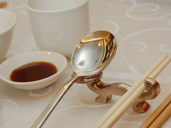 Chopsticks, spoon, bowl and plate arranged as Chinese tableware