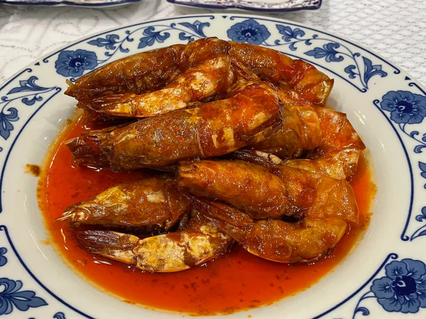Shandong-style braised prawns served on a porcelain plate