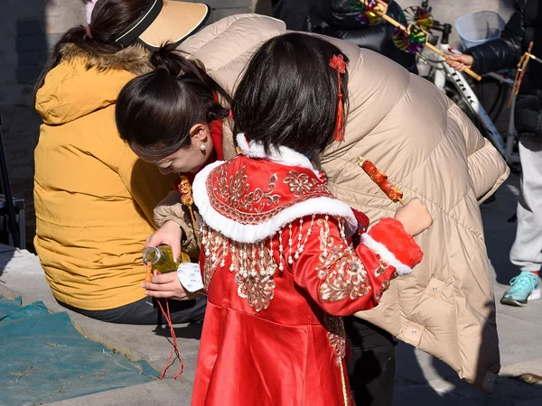 A girl eating tanghulu at Beijing’s Changdian Temple Fair
