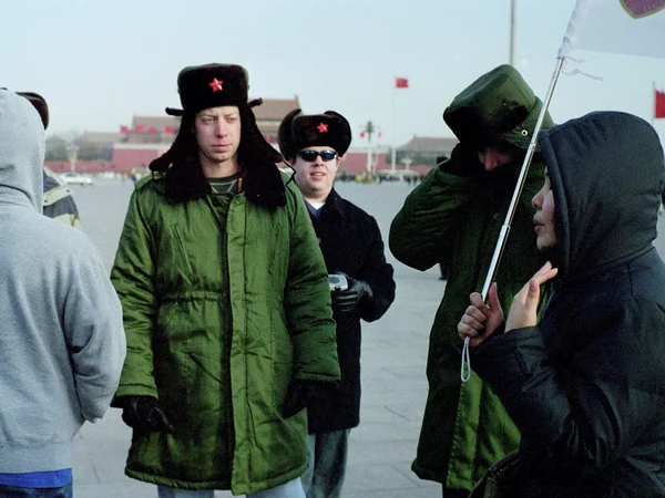 Foreign visitors following a tour guide at Tiananmen Square in Beijing