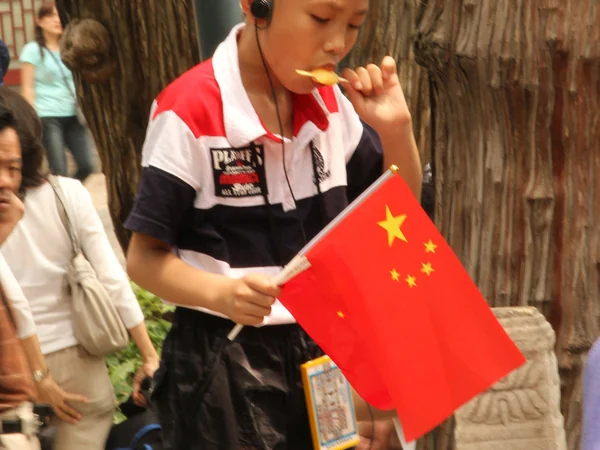 A young visitor carrying a Chinese flag in Beijing’s Forbidden City A young visitor carrying a Chinese flag in Beijing’s Forbidden City