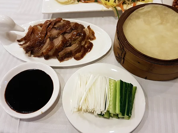 Carved Peking duck served with thin pancakes and garnishes Carved Peking duck served with thin pancakes and garnishes
