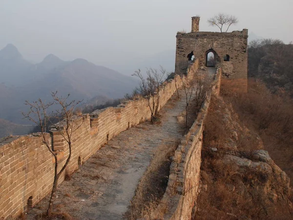 Unrestored Great Wall following a forested ridge near Qinhuangdao