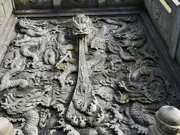 Chinese dragon carved in stone as part of historic architecture Chinese dragon carved in stone as part of historic architecture