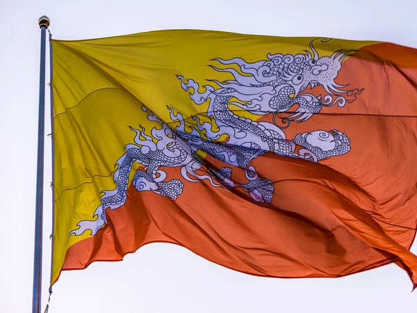 Bhutan’s national flag flying with the white Druk dragon across its diagonal field Bhutan’s national flag flying with the white Druk dragon across its diagonal field