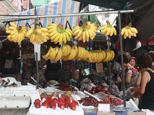 A vendor arranging fresh fruit at a Chinese market A vendor arranging fresh fruit at a Chinese market