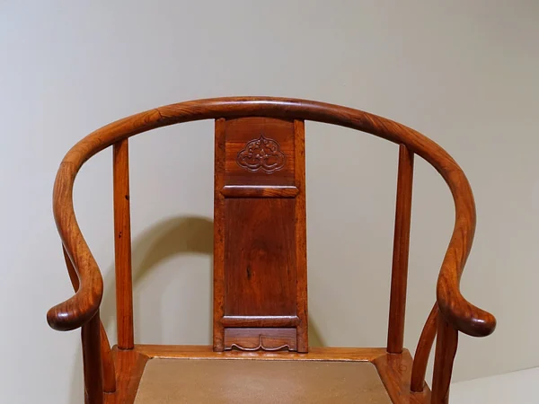 Late Ming dynasty huanghuali horseshoe-back armchair in a museum display