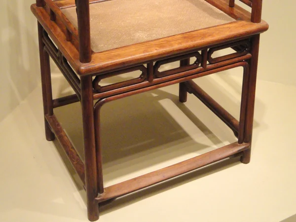 Late Ming to Qing dynasty huanghuali low-back armchair in a museum display