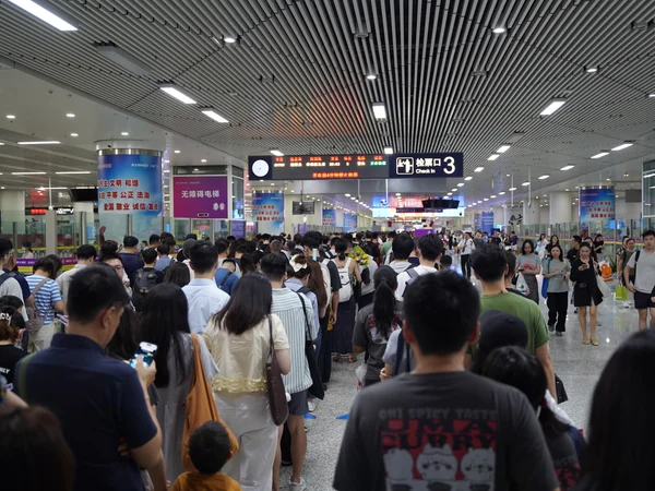 Passengers queueing to board a high-speed train at Futian Railway Station