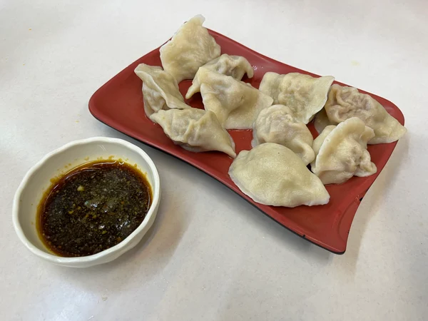 Dumplings served with ginger soy dipping sauce at a Chinese restaurant Dumplings served with ginger soy dipping sauce at a Chinese restaurant