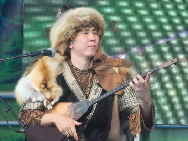 Kazakh musician playing a two-stringed dombra