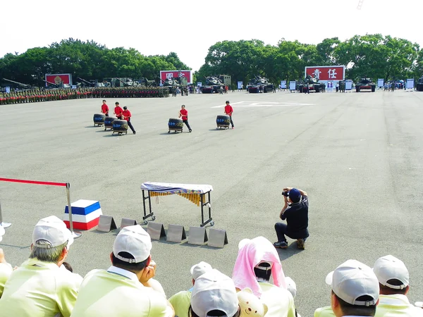 A youth team performing on large Chinese drums at an outdoor event