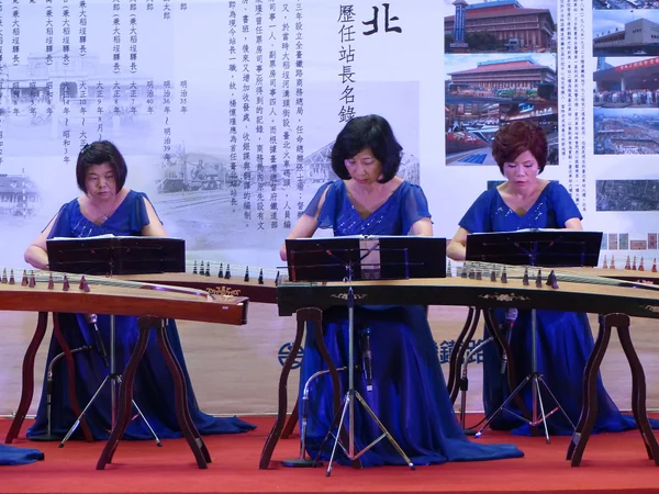 Musician performing on a guzheng zither