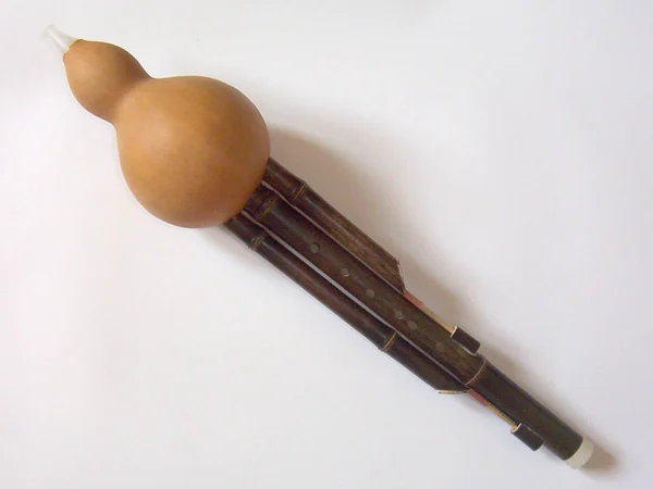 A hulusi gourd flute shown against a plain background