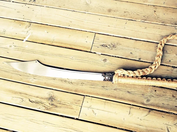 A Chinese pudao polearm placed on wooden boards