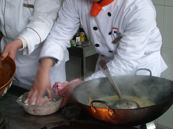 Chefs cooking food over wok stoves in Nanjing China Chefs cooking food over wok stoves in Nanjing China