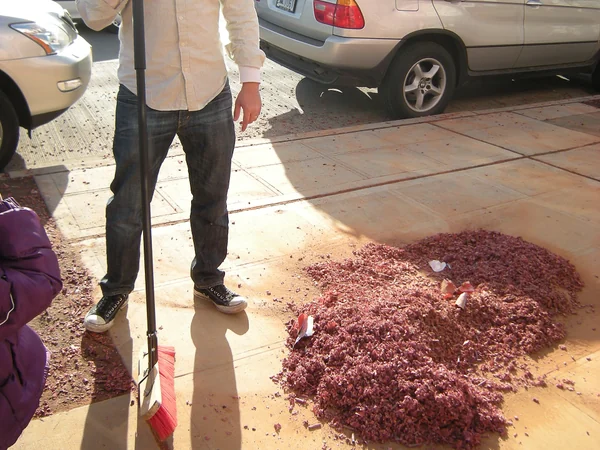 A worker clears firecracker debris after a Chinese New Year celebration