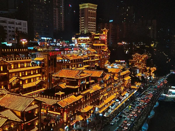 Hongya Cave illuminated beside modern Chongqing at night in October