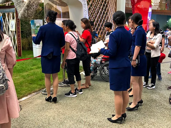 Visitor guides at a Beijing exhibition illustrating accountable local assistance Visitor guides at a Beijing exhibition illustrating accountable local assistance