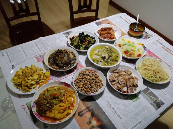 A table prepared with shared dishes for a Chinese New Year reunion meal