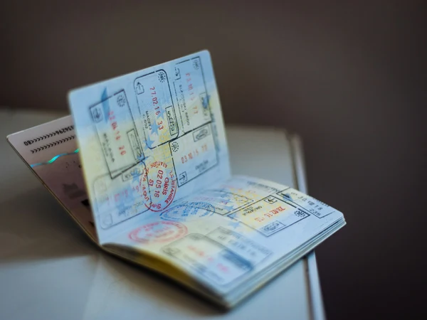 Open passport with international travel stamps for China entry planning Open passport with international travel stamps for China entry planning